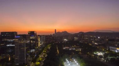 Sunset 'te parlayan Santiago City. Hava Hızı Hızı, Zaman Hızı. Akşam Alacakaranlığı. Mavi Saat. Las Condes Komünü. Şili. İnsansız Hava Aracı Yana ve Yukarı Uçar