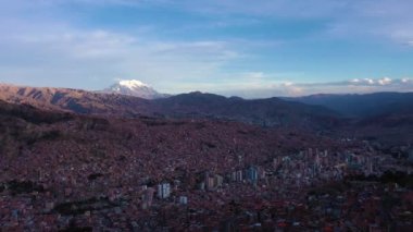 La Paz Cityscape ve Illimani Dağı. Hava görüntüsü. Bolivya 'da. Altın Saat. İnsansız hava aracı yandan uçuyor. Geniş Görüntü