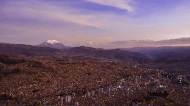 Akşam Alacakaranlığı 'nda La Paz Cityscape ve Illimani Dağı. Hava Hızı, Hiper Hata. Bolivya 'da. Mavi Saat. İnsansız hava aracı yandan uçuyor. Geniş Görüntü