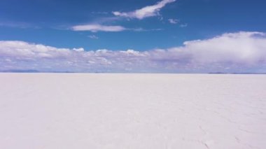 Güneşli bir günde Uyuni Tuz Düzlükleri. Hava görüntüsü. Altiplano, Bolivya. Kurak Mevsim. Altıgen Tuz oluşumları ve Çatlak desenleri. İHA alçaktan geriye doğru uçuyor. Geniş Görüntü