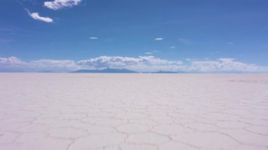 Güneşli bir günde Uyuni Tuz Düzlükleri. Salar De Uyuni. Hava görüntüsü. Altiplano, Bolivya. Kurak Mevsim. Altıgen Tuz oluşumları. İnsansız hava aracı alçaktan uçuyor. Geniş Görüntü