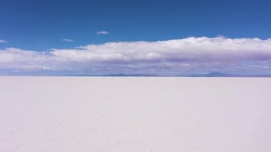Güneşli bir günde Uyuni Tuz Düzlükleri. Hava görüntüsü. Altiplano, Bolivya. Kurak Mevsim. Tuz çatlakları ve oluşumları. İnsansız hava aracı alçaktan uçuyor. Geniş Görüntü