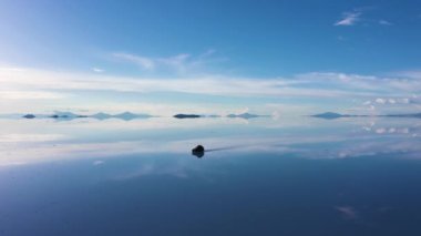 Uyuni Tuz Düzlükleri. Salar De Uyuni. Hava görüntüsü. Altiplano, Bolivya. Yağmur mevsimi. SUV arabası. Göl yüzeyinde Bulutların Yansıması. İnsansız Hava Aracı Yan Uçuyor