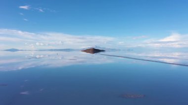 Uyuni Tuz Düzlükleri. Hava görüntüsü. Altiplano, Bolivya. Yağmur mevsimi. Tunupa Volkanı ve Incahuasi Adası. Göl yüzeyinde Bulutların Yansıması. Drone İleri ve Yukarı Uçuyor