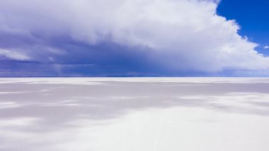 Uyuni Tuz Düzlükleri. Salar De Uyuni. Hava Hızı Hızı, Zaman Hızı. Altiplano, Bolivya. Kurak Mevsim. Dramatik, Fırtınalı Gökyüzü. İnsansız hava aracı yandan uçuyor. Gölgeler Göl yüzeyinde ilerliyor