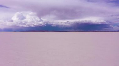 Uyuni Tuz Düzlükleri. Salar De Uyuni. Hava görüntüsü. Altiplano, Bolivya. Kurak Mevsim. Dramatik ve Fırtınalı Gökyüzü. İHA alçaktan geriye doğru uçuyor. Geniş Görüntü