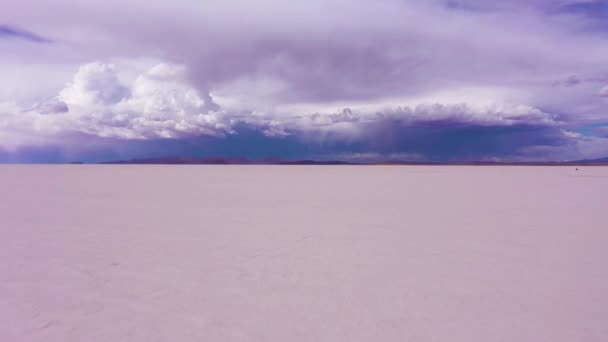 ウユニ塩フラッツ サラー ウユニ 空中展望 ボリビアのアルティプラノ ドラマティックでストーミーな空 ドローンは低レベルで後方に飛ぶ ワイドショット — ストック動画
