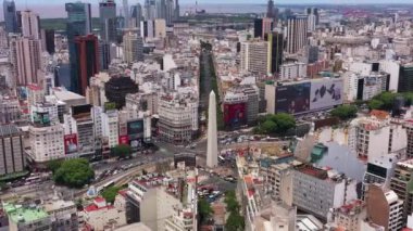 BUENOS AIRES, ARJENTINA 23 ARALIK 2022: Güneşli bir günde Buenos Aires City. Obelisk ve 9 Temmuz Bulvarı. Hava görüntüsü. Arjantin. Yörüngede, aşağı doğru uç, yukarı eğ.