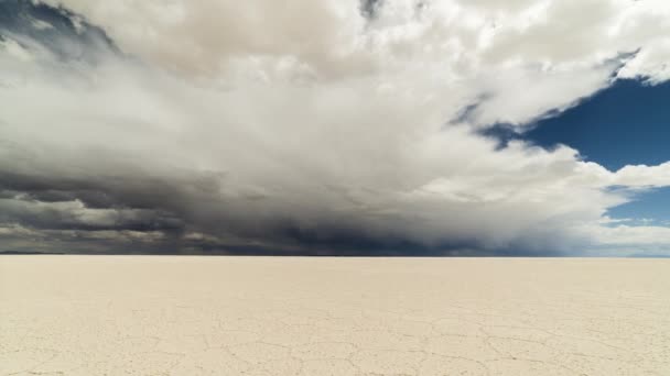 晴れた日にはウユニ塩のフラット サラー ウユニ ボリビアのアルティプラノ 空の劇的な美しい雲 六角形の塩の形成とクラックパターン ワイドショット 時間の経過 — ストック動画
