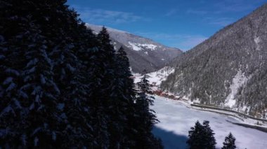 Uzungol Gölü kışın buzla kaplıdır. Ağaçlı Tepeler ve Dağlar. Hava görüntüsü. Trabzon ili, Türkiye. İnsansız Hava Aracı Yan Uçuyor