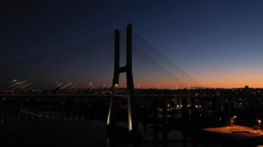 Akşam Alacakaranlığı 'nda Vasco da Gama Kablo Kalan Köprüsü ve Lizbon Şehri' ni aydınlattı. Lizbon, Portekiz. Mavi Saat. Hava görüntüsü. Yörüngede. Geniş Görüntü