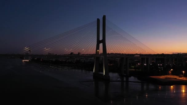 灯火通明的Vasco Gama Cable Stayed Bridge和Lisbon Skyline在暮色黄昏 葡萄牙里斯本 蓝色一小时 空中景观 无人机飞向天桥和上游 — 图库视频影像