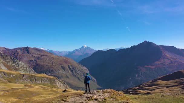 ブルージャケットのハイカーマンが山を眺めている ヒルズと山々 クロワイス ボナムス フランスアルプス フランス アリアルビュー ドローン フライ フォワード — ストック動画
