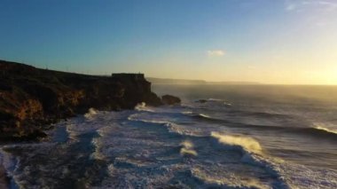 North Beach, Cliffs, Fort and Atlantic Ocean Sunset 'te. Nazare, Portekiz. Büyük Dalgalar. Hava görüntüsü. Drone İleri ve Yukarı Uçuyor
