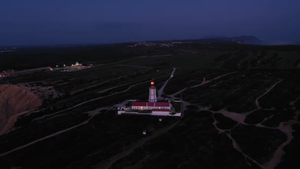 イブニング トワイライトの灯台カボ エスピシェル ライトビームを回す ブルーアワー ポルトランド アリアルビュー ドローンが下に飛び出して ティルトアップ ワイドショット — ストック動画