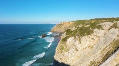 Adraga Sahili, Kayalıklar ve Atlantik Okyanusu Dalgaları. Portekiz. Hava görüntüsü. İHA uçurumun üzerinden ileri uçuyor. Çekim Kuruluyor