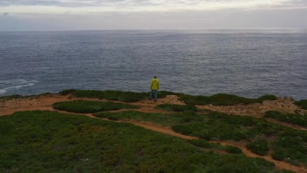 Lonely Man Yellow Jacket Está Borda Penhasco Olhando Para Oceano — Vídeo de Stock