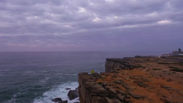 Sarı Ceketli Yalnız Adam Uçurumun Kenarında Duruyor Bulutlu Gece Atlantik — Stok video
