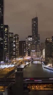 Şikago Şehri ve Chicago Nehri 'nin Kış Gecesi Şehir manzarası. New East Side ve Streeterville. Hava Hızı Hızı, Zaman Hızı. Amerika Birleşik Devletleri. Drone yukarı doğru uçuyor. Dikey Video