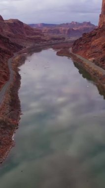 Cloudy Morning 'de Colorado Nehri ve Red Sandstone Dağları. Sudaki Gökyüzü Yansıması. Grand County, Utah, ABD. Hava görüntüsü. Drone İleri Uçuyor, Eğil. Şutu göster. Dikey Video