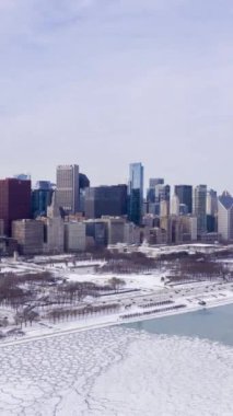Chicago 'nun Kentsel Skyline ve Donmuş Göl Michigan Kış Dondurma Günü' nde Ice Lumps ile. Hava Hızı Hızı, Zaman Hızı. Amerika Birleşik Devletleri. İnsansız hava aracı yandan uçuyor. Dikey Video