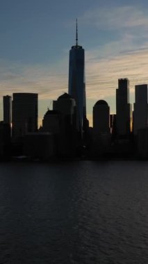 Aşağı Manhattan, New York, Sunrise 'da. Hava görüntüsü. Amerika Birleşik Devletleri. Güneş doğuyor. Drone yukarı doğru uçuyor. Dikey Video