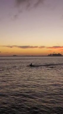 Sunset 'te Jet Ski' nin silueti. Miami, Florida, ABD. Hava görüntüsü. İnsansız hava aracı alçaktan uçuyor. Dikey Video