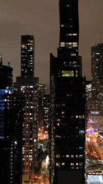 Chicago City 'nin Urban Skyline' ı ve kışın Gece Şikago Nehri. New East Side ve Streeterville. Hava görüntüsü. Amerika Birleşik Devletleri. İnsansız hava aracı yandan uçuyor. Dikey Video