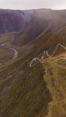 Katu-Yarik dağ geçidi. Chulyshman Nehri Vadisi. Viraj Yolu. Hava görüntüsü. Altai, Rusya. Drone İleri Uçuyor. Dikey Video