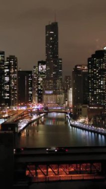 Şikago Şehri ve Chicago Nehri 'nin Kış Gecesi Şehir manzarası. New East Side ve Streeterville. Hava görüntüsü. Amerika Birleşik Devletleri. Drone yukarı doğru uçuyor. Dikey Video