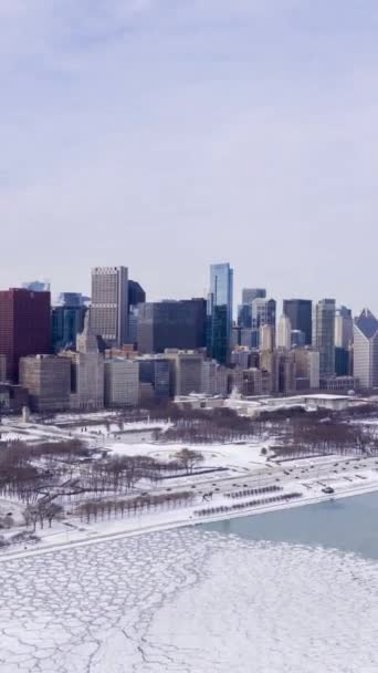 シカゴ ループの都市スカイラインとミシガン湖の凍結 冬の霜の日にアイスループ 空中ハイパーラップ タイムラップス アメリカ合衆国 ドローン フライズ サイドウェイ バーティカルビデオ — ストック動画