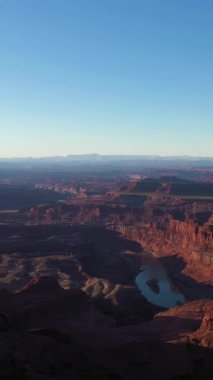 Sunrise 'daki Ölü At Noktası Eyalet Parkı. Colorado Nehri, Kızıl Kanyon ve Clear Sky. Utah, ABD. Meander Overlook 'dan hava görüntüsü. Drone geriye doğru uçuyor. Dikey Video