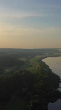 Yazın Sunrise 'da Oka Nehri, Meadow ve Forest. Rusya 'nın manzarası. Kırsal kesimde. Hava görüntüsü. Drone ileri ve yukarı doğru uçuyor. Dikey Video