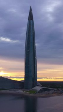 SaINT-PETERSBURG, RUSSIA - 20 Haziran 2019: Günbatımında Lakhta Center Gökdeleni. Hava görüntüsü. - Rusya. Renkli Gökyüzü. Drone yukarı doğru uçuyor. Dikey Video