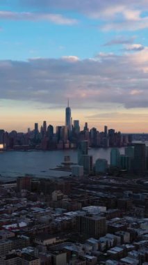 Aşağı Manhattan 'dan Urban Skyline, Jersey City ve Hudson River. New York, Sunset 'te. Hava görüntüsü. Amerika Birleşik Devletleri. Drone geriye doğru uçuyor. Dikey Video