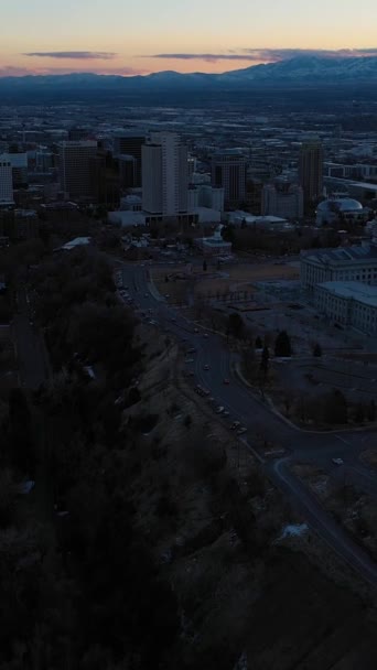 冬のサンセットでソルトレイクシティ アメリカ合衆国ユタ州 アリアルビュー ブルーアワー キャピトルヒル ドローン フライが先に進む ティルトアップ ショットを明らかに バーティカルビデオ — ストック動画