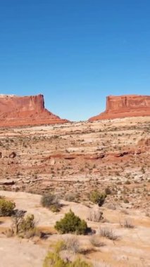 Güneşli günde Merrimac ve Monitor Buttes. Hava görüntüsü. Grand County, Utah, ABD. Drone İleri Uçuyor. Dikey Video