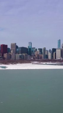 Chicago 'nun Kentsel Skyline ve Donmuş Göl Michigan Kış Günü' nde Ice Lumps ile. Hava görüntüsü. Amerika Birleşik Devletleri. Drone yukarı doğru uçuyor. Dikey Video