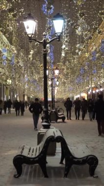 MOSCOW, RUSSIA - 25 Aralık 2020: Nikolskaya Yayası Caddesi 'ni aydınlattı. Kış akşamında yürüyen insanlar. Noel tatilleri. Moskova, Rusya. Orta Çekim... dikey Video