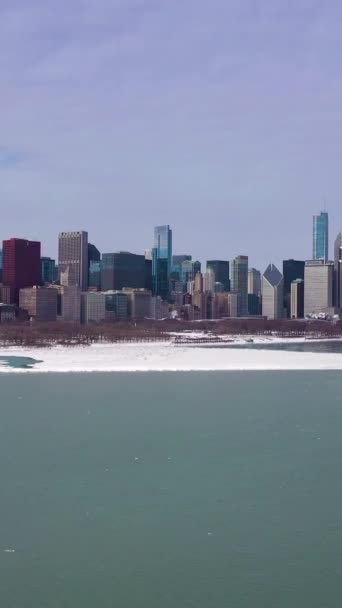 芝加哥环城的城市天际线和密歇根州结冰湖带着冰块在冬日 空中景观 美利坚合众国 无人机向上飞 垂直录像 — 图库视频影像