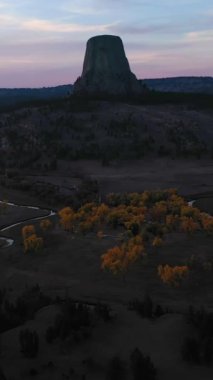 Akşam Alacakaranlığı 'nda Şeytan Kulesi Butte ve Belle Fourche Nehri. Crook County 'de. Wyoming, ABD. Hava görüntüsü. Drone İleri Uçuyor, Eğil. Şutu göster. Dikey Video