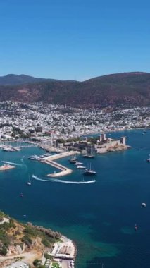 Güneşli bir günde Bodrum Şehri. Hava görüntüsü. Türk Rivierası. Hindi. Drone geriye doğru uçuyor. Dikey Video