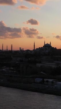 Günbatımında Fatih Bölgesi 'ndeki camiler. İstanbul, Türkiye. Hava görüntüsü. Drone Yana ve Yukarı Uçuyor. Dikey Video