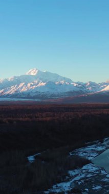 Chulitna Nehri, Ruth Buzulu ve Sunset 'teki Denali Dağı. Alaska, ABD. Hava görüntüsü. Drone Yana ve Yukarı Uçuyor. Orta boy shot. Dikey Video