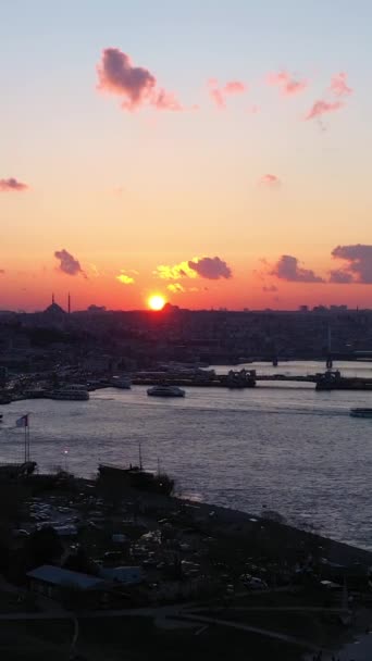 在日落城的伊斯坦布尔城市轮廓 金角湾和加拉塔大桥空中景观 无人机向上飞 垂直录像 — 图库视频影像