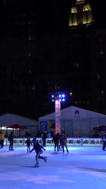 ニューヨークシティ アメリカ January 2021 コヴィド 19パンデミックの間 冬のマンハッタンのブライアントパークでアイスクススケートを着ている人々 垂直ビデオ — ストック動画