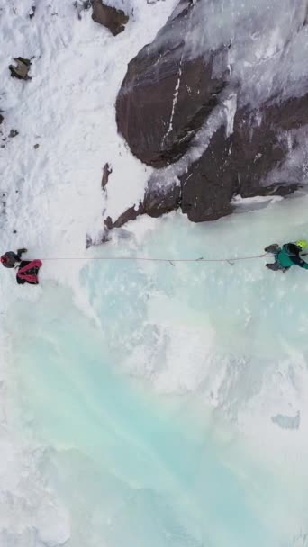 Ice Climbing Frozen Waterfall Aerial Top View Mountaineer Man Leading — Stock Video