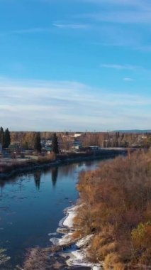 Fairbanks City ve Chena River Sunny Autumn Morning 'de. Alaska, ABD. Hava görüntüsü. Drone ileri ve yukarı doğru uçuyor. Dikey Video