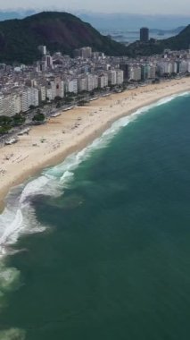 Güneşli bir günde Rio de Janeiro 'da. Copacabana Sahili ve Atlantik Okyanusu. Hava görüntüsü. Brezilya. Drone İleri Uçuyor, Eğil. Şutu göster. Dikey Video