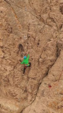 Tırmanan Adam Kaya tırmanışı. Tamgaly Tas, Kazakistan 'daki kayalıklar. Hava görüntüsü. Yörüngede. Dikey Video